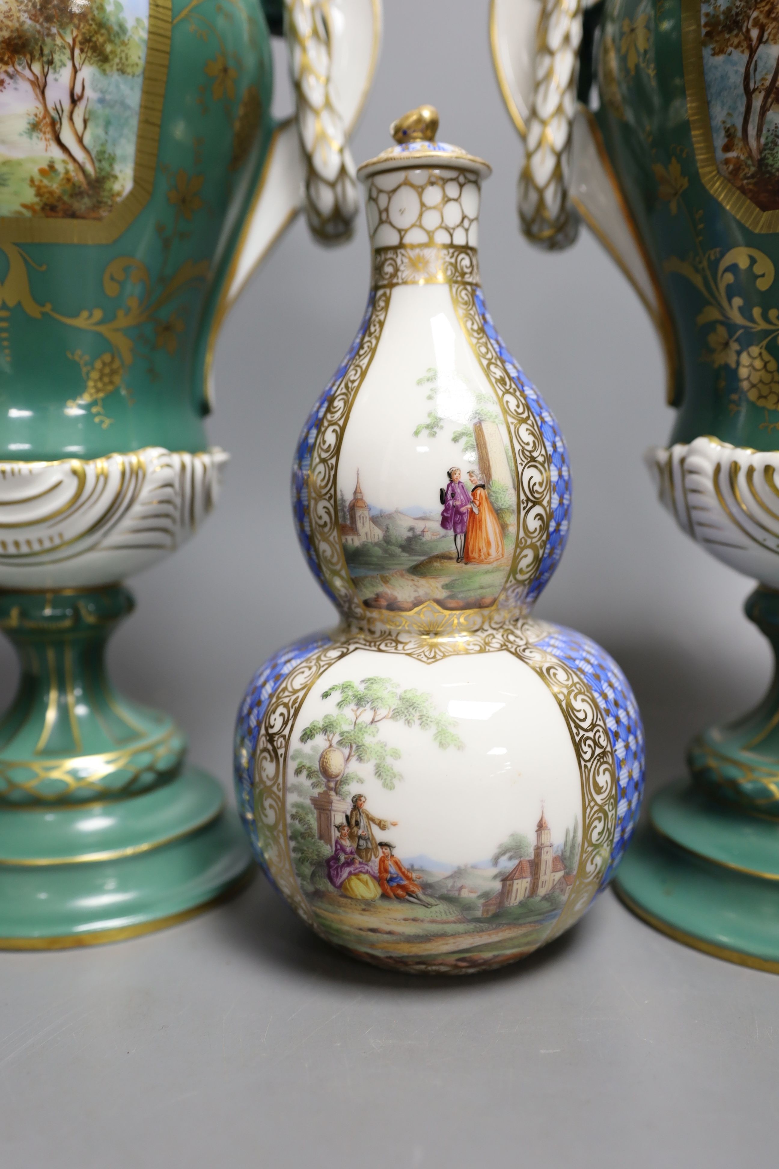 A pair of early 20th century Dresden vases painted with landscapes on an avocado green ground, 24cm high together with a German bottle vase and cover painted with four landscape panels separated by blue and white panels